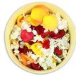 A calm, overhead view reveals a smooth, pale yellow ceramic bowl filled right to its rim with freshly prepared rose and hydrangea petals, arranged as a heartfelt funeral tribute. The bowl's soft, creamy glaze creates a warm frame around the contents, while inside, rose petals in deep crimson, rich burgundy, and bright scarlet are layered in relaxed clusters, each one velvety and full, edges gently ruffled. These are balanced by generous sweeps of golden yellow and mellow peach-apricot petals, their lighter tones catching the light so that some appear almost luminous, like early morning sunshine filtering through Harlesden's terraced streets. Interwoven throughout are countless small, ruffled white hydrangea florets, their delicate, almost paper-fine texture providing a gentle contrast to the more substantial rose petals. The white blossoms introduce a sense of purity, calm, and quiet space within the richer colours, evoking the stillness of a moment of silence at a local church or crematorium. The petals rest loosely, with tiny gaps where the shadows fall dark and soft, suggesting movement and the possibility of being tenderly lifted, scattered, or shared among family members. Although the image is static, it conveys an almost tangible fragrance: the familiar, soothing scent of roses mixed with the subtle freshness of hydrangea, as though just prepared in a Harlesden florist's workroom. This simple yet abundant bowl of petals speaks of care, remembrance, and the human wish to say goodbye with beauty-perfect for scattering over a coffin, lining a remembrance table, or accompanying a memorial service where love and loss are held side by side.